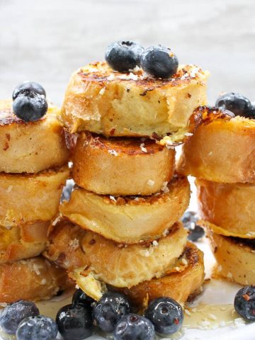 This Coconut French Toast is made with thick, dense bread, crusted with coconut, smothered in fruit, and drizzled with honey.