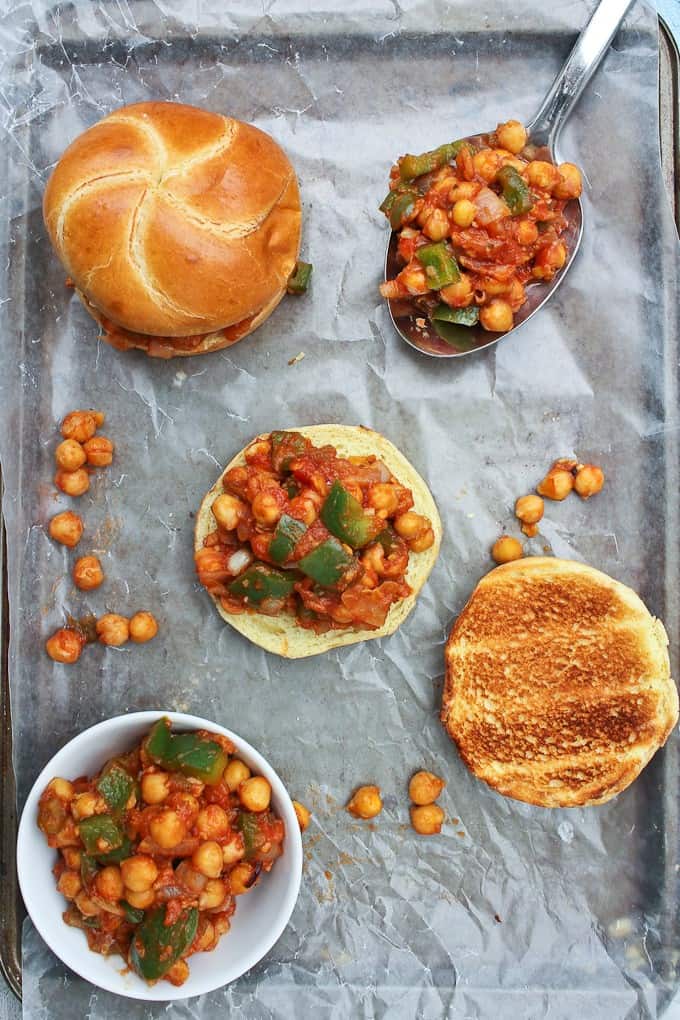 Toasted buns loaded with vegan sloppy joe mixture laid out on a baking sheet