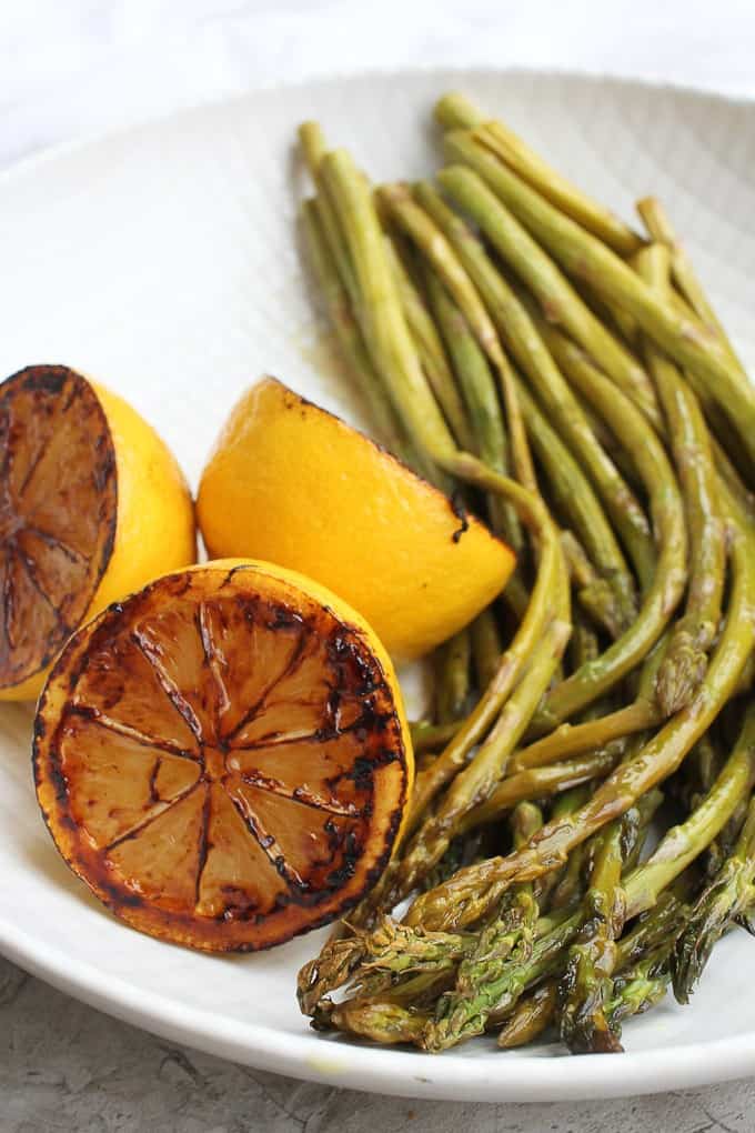 Oven-roasted asparagus and charred lemons on a plate