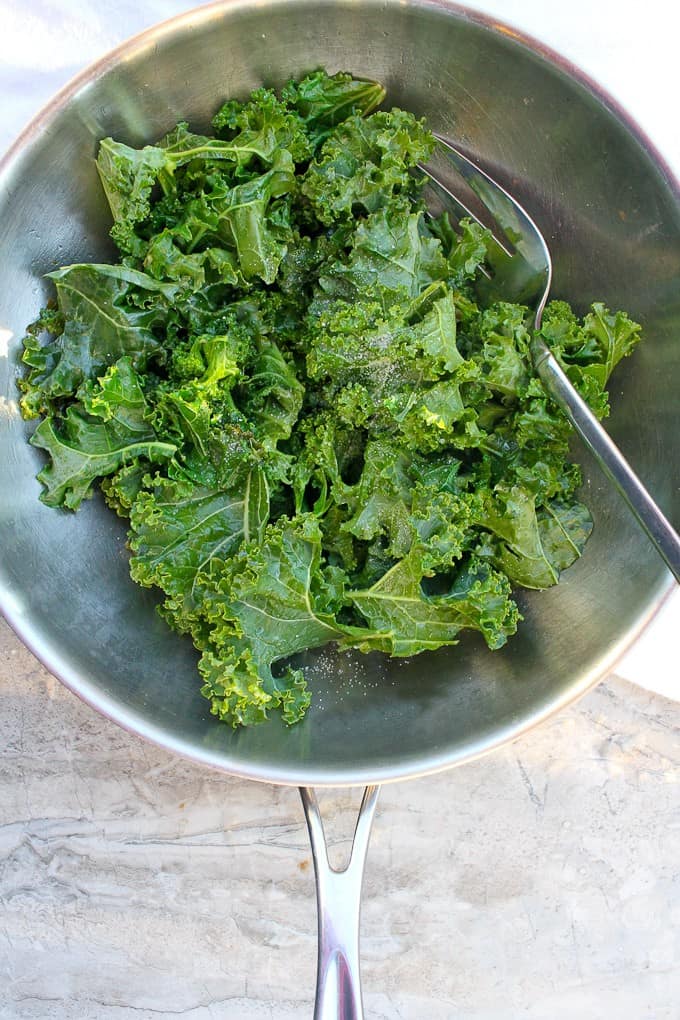 Braised kale with apple cider vinegar in a large saute pan