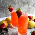 strawberry lemonade in glasses with lavender petals, strawberries, and lemons