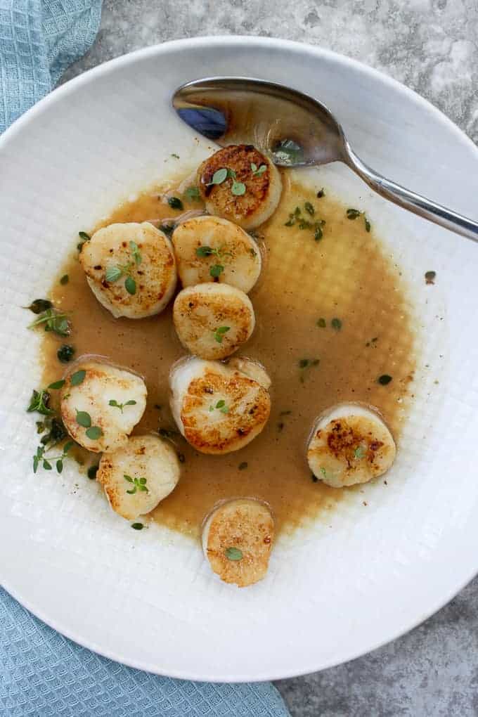 Seared Sea Scallops with wine sauce in a serving dish.