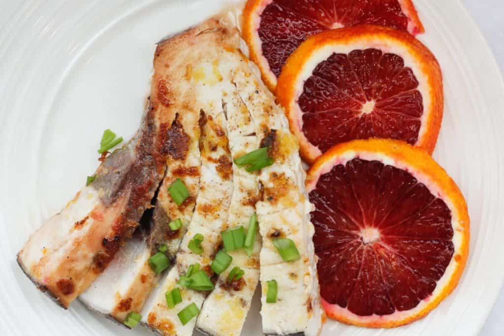 Pan-Seared Swordfish on a plate with blood orange slices