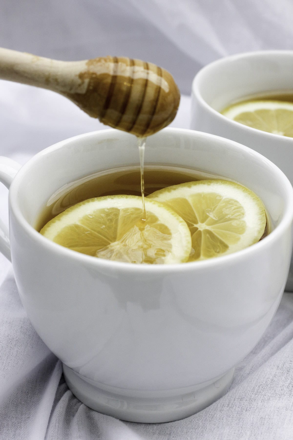 drizzling honey into a cup of hot tea.
