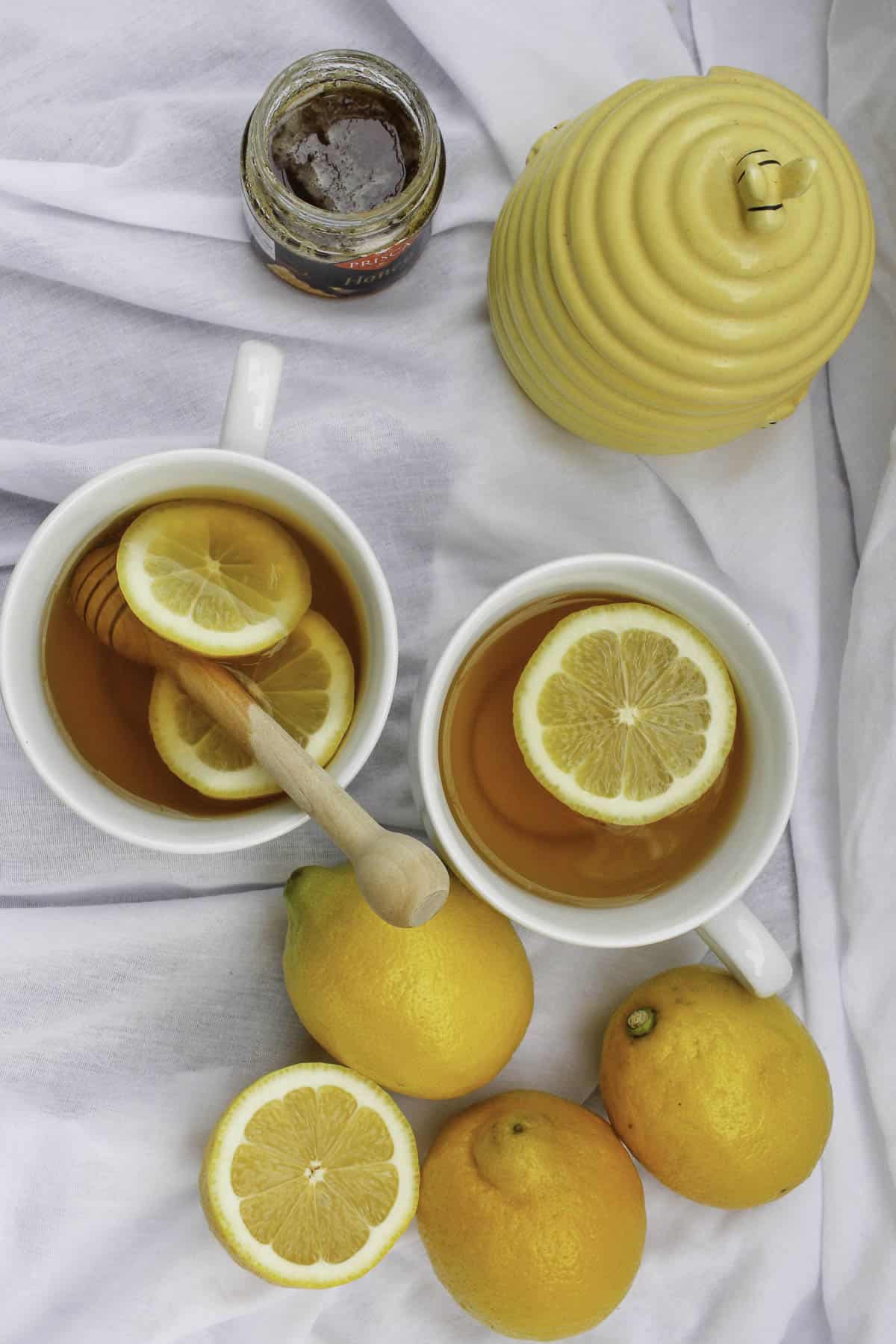tabletop with hot toddys, honey, and lemons.