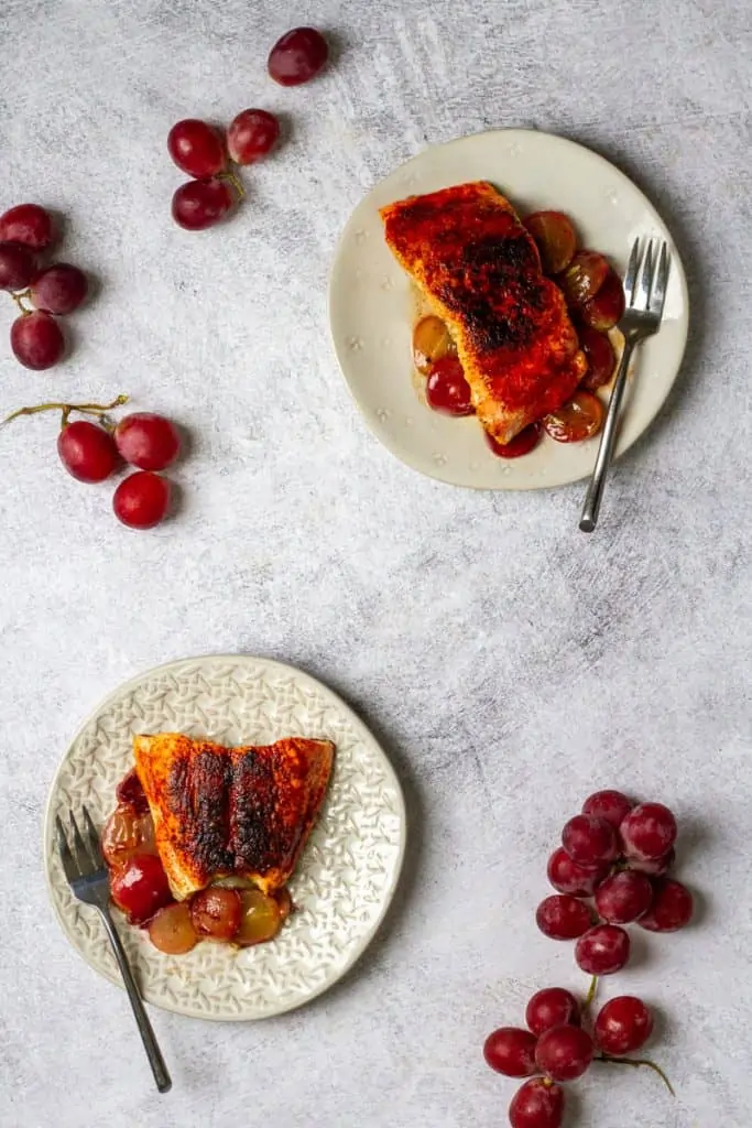 smoked paprika salmon on plates with rosemary grapes