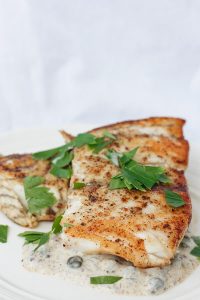 This Seared Barramundi (Asian Sea Bass) is cooked to perfection in browned butter, and served with a tangy Mustard Caper Sauce. This flavorful dish is ready in under 20 minutes, and is perfect for Date Night! champagne-tastes.com