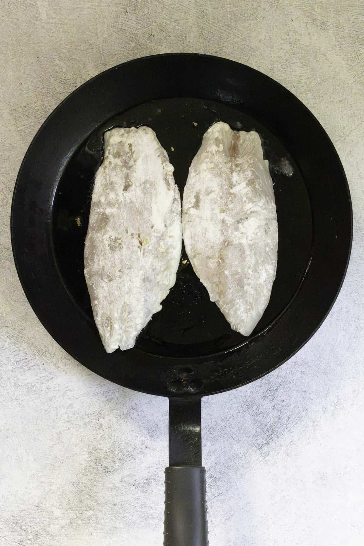 fish fillets in hot pan.