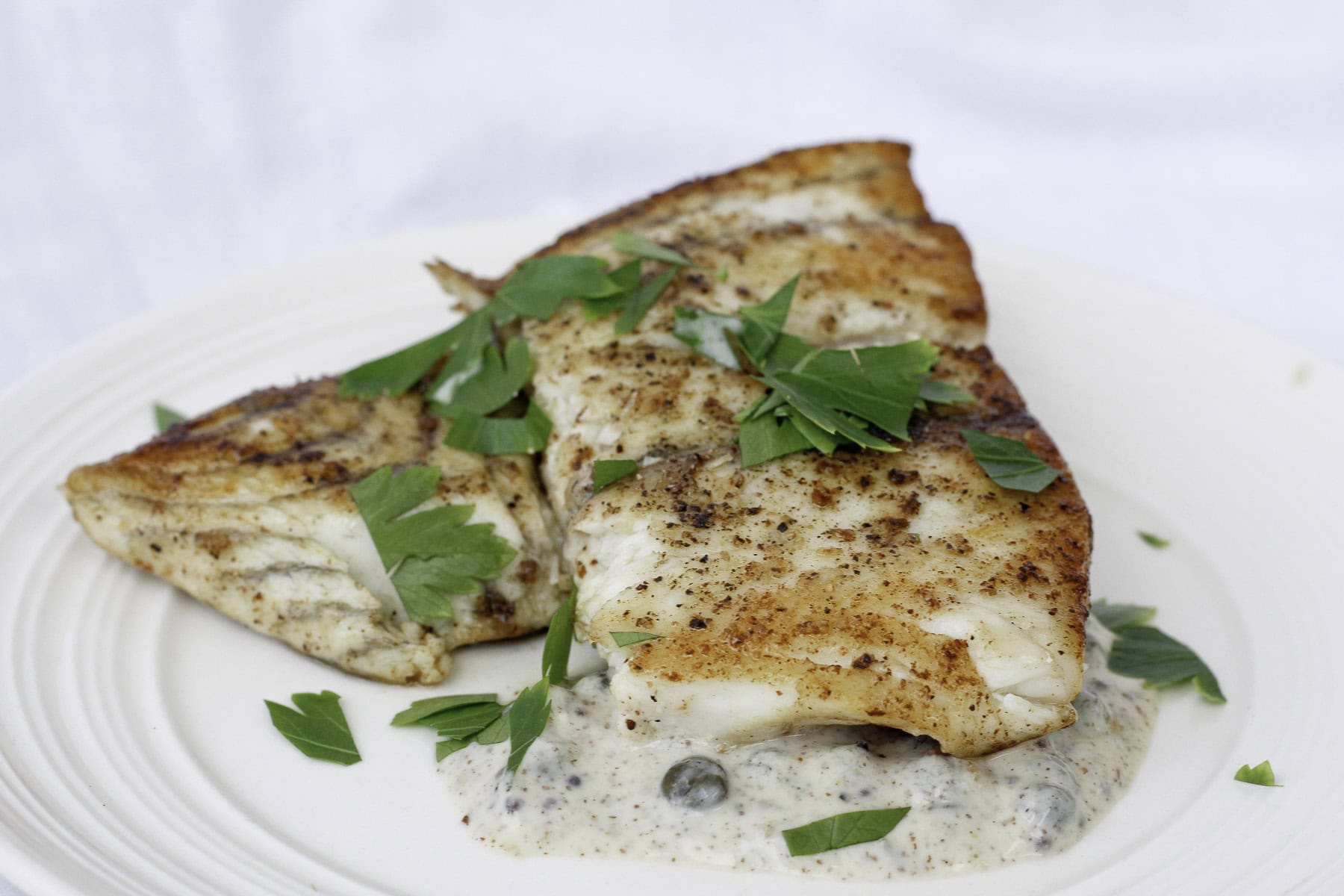 pan-seared barramundi on plate.