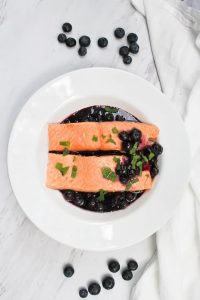 This Poached Salmon with Blueberry Sauce is made with decadent king salmon poached in spiced white wine, and served with an easy blueberry sauce. champagne-tastes.com #ad