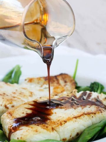 This Kentucky Bourbon Seared Halibut is Date Night at its best!  It features delicious, meaty halibut drizzled with a quick bourbon sauce, served over a bed of wilted spinach.