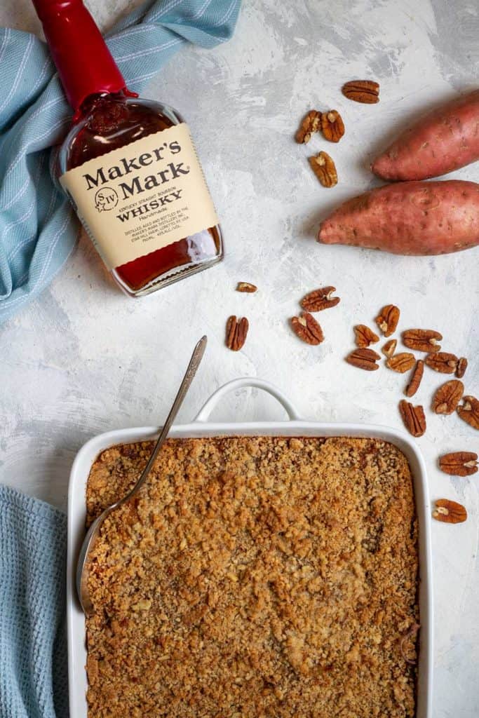 bourbon sweet potato casserole in a serving dish with makers mark