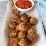 Albondigas de pescado (fish balls / fish meatballs) on a serving tray with tomato sauce
