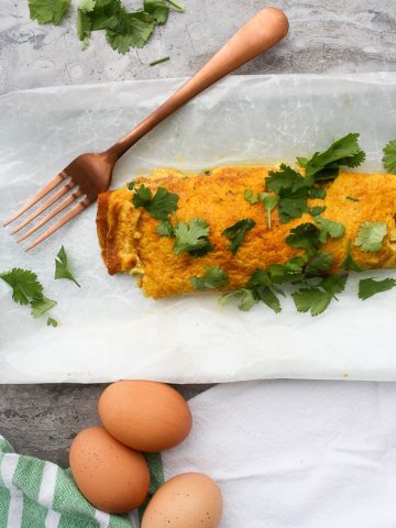 Masala Omelette with eggs and cilantro on the counter