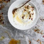 Labneh in a bowl with spices, herbs, and honey