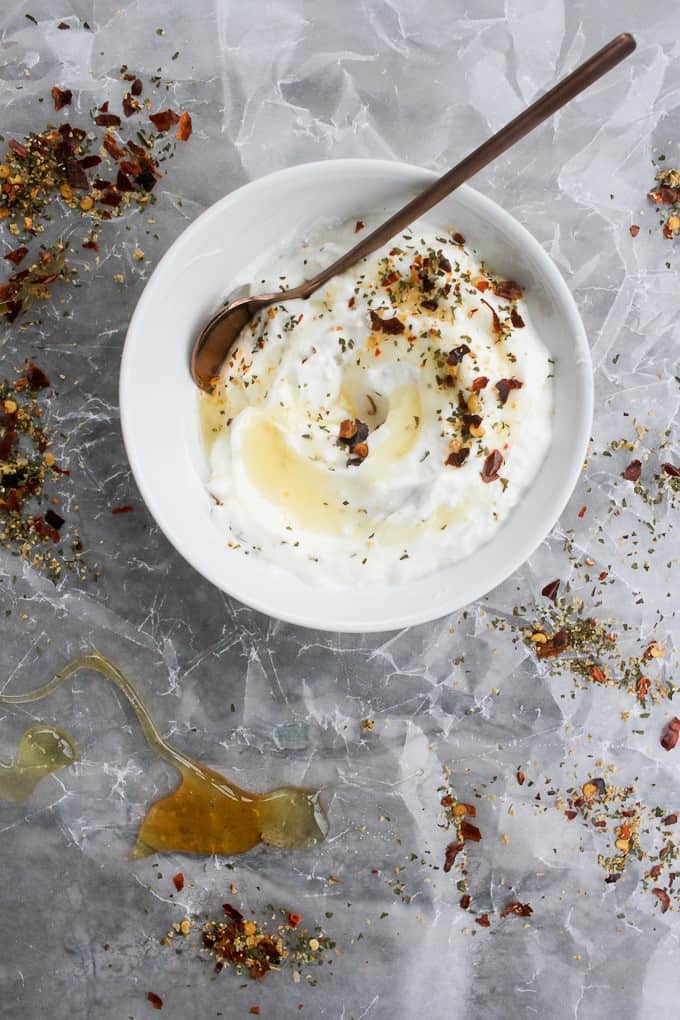 Labneh in a bowl with spices, herbs, and honey