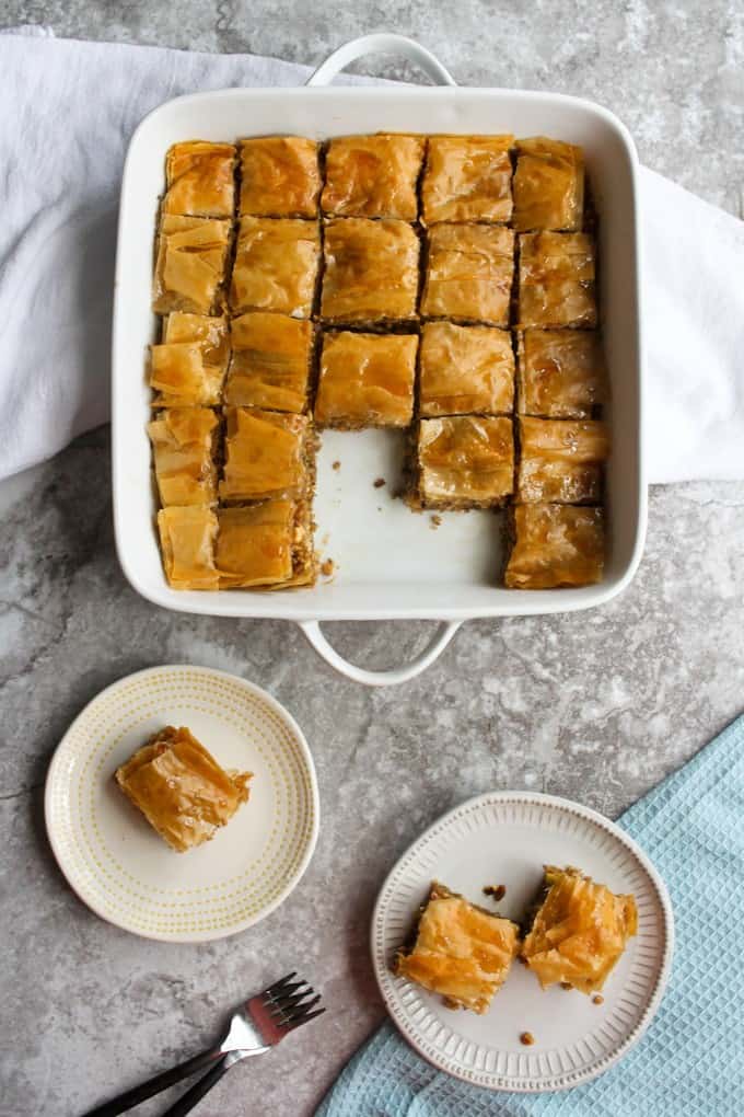 cooked baklava in a serving dish and plates