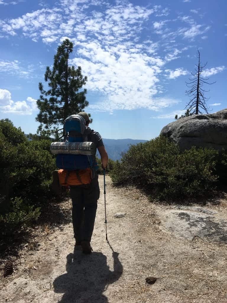 Backpacker hiking on trail.