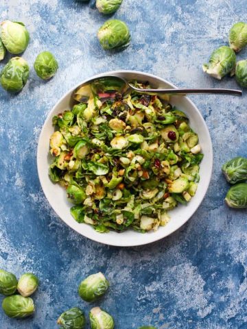 Shaved brussels sprouts salad in a serving bowl.