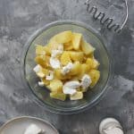 Adding butter and cheese to the potatoes.
