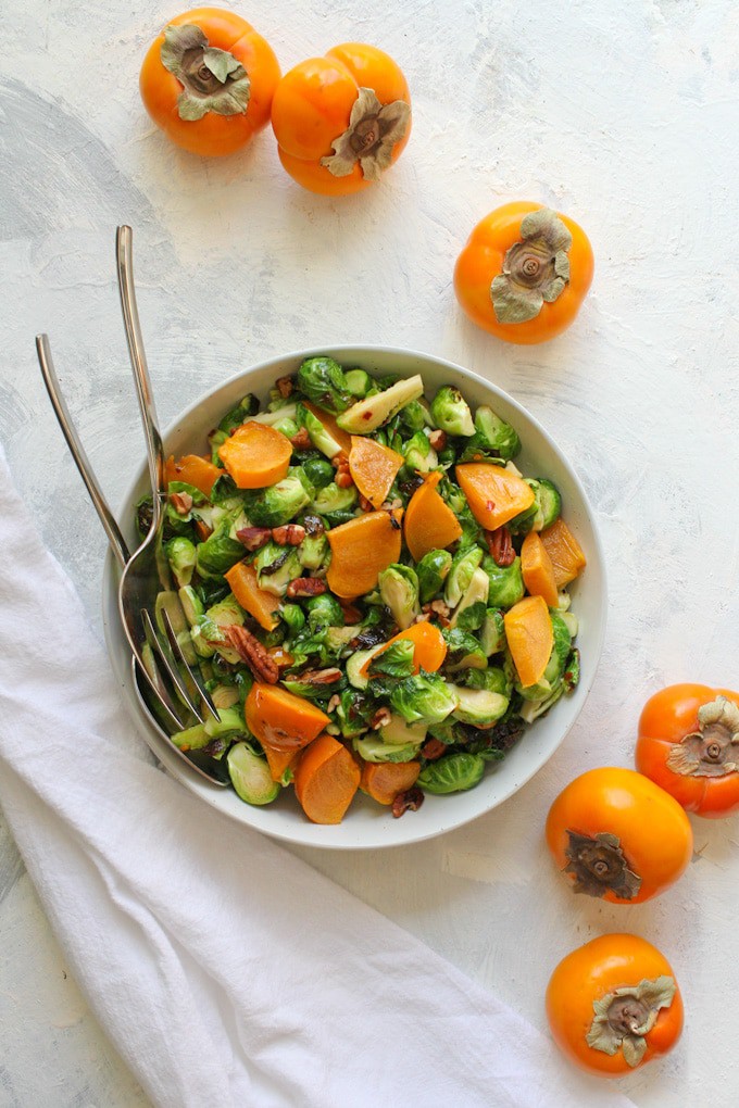roasted brussels sprouts salad with persimmon in a serving dish