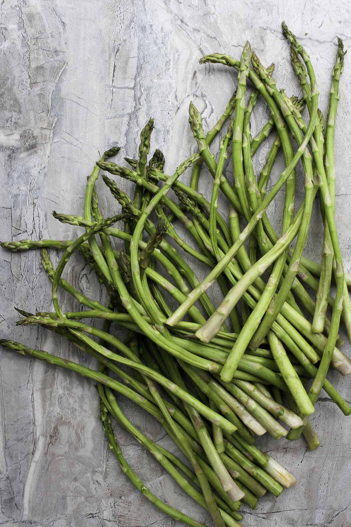 This Oven-Roasted Asparagus with Charred Lemon is drizzled with olive oil, white vinegar, and fresh lemon juice. It's fast, easy, and delicious! asparagus on a countertop.