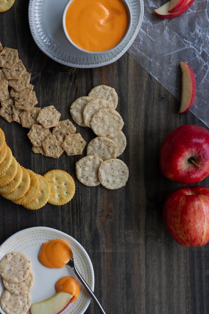 roasted red pepper dip on a serving tray with crackers and apples