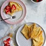 french crepe recipe: basic crepes on a serving dish with strawberries