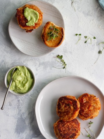 salmon burgers with avocado sauce on a serving plate