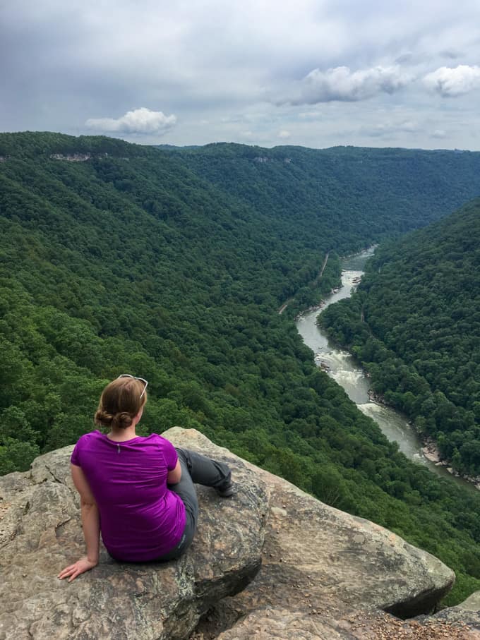 Woman sitting at Endless Wall Trail Overlook.