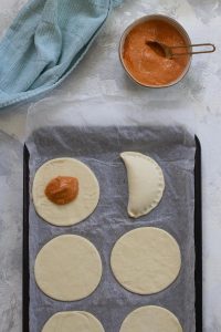 Add pumpkin filling to the dough, and seal empanada