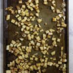 uncooked seasoned potatoes on a baking sheet.