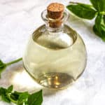 basil simple syrup in a glass bottle