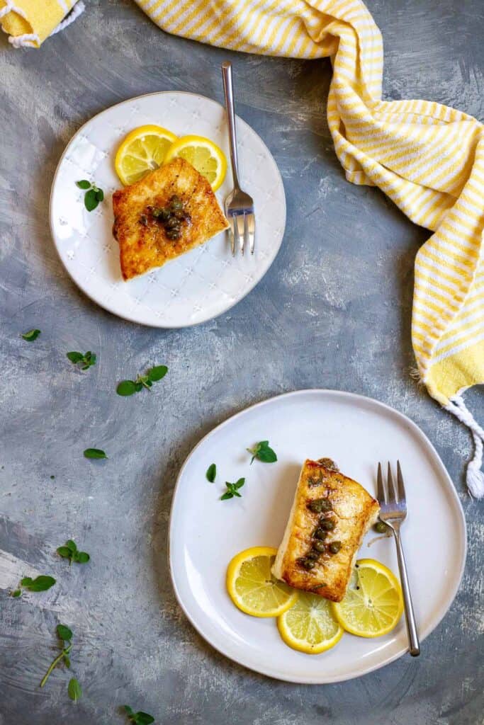 Pan-Seared Halibut with Lemon Caper Sauce on Plates.