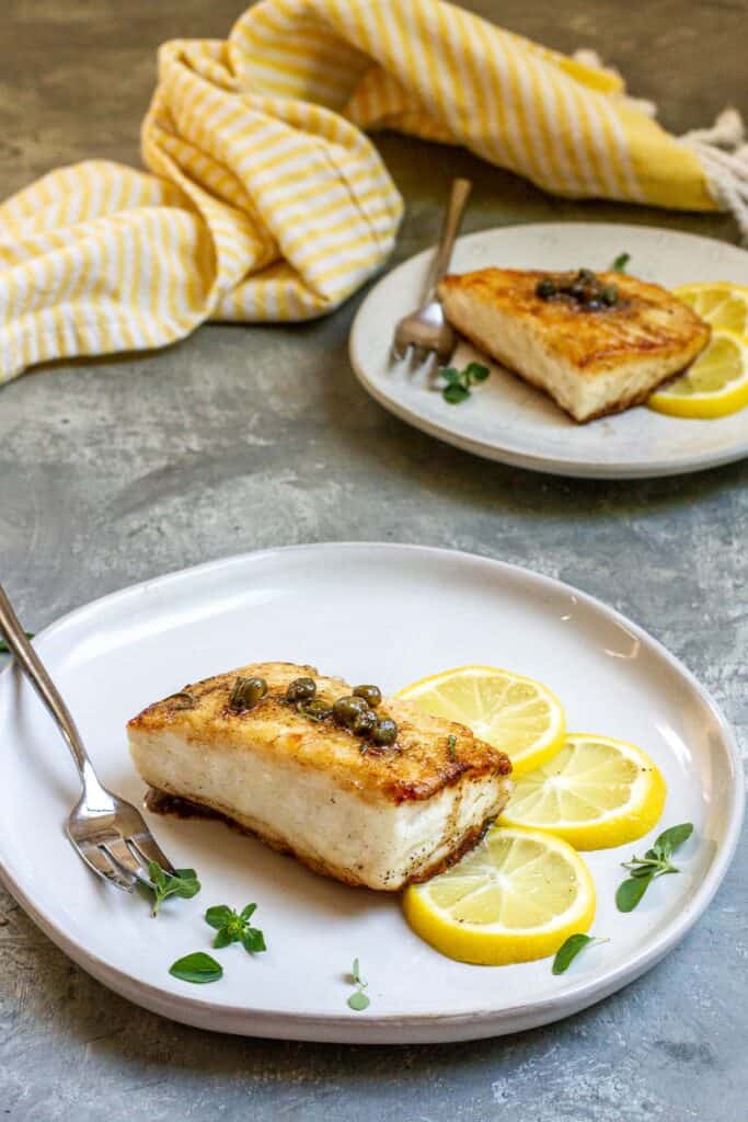pan-seared halibut fillets on a plate.