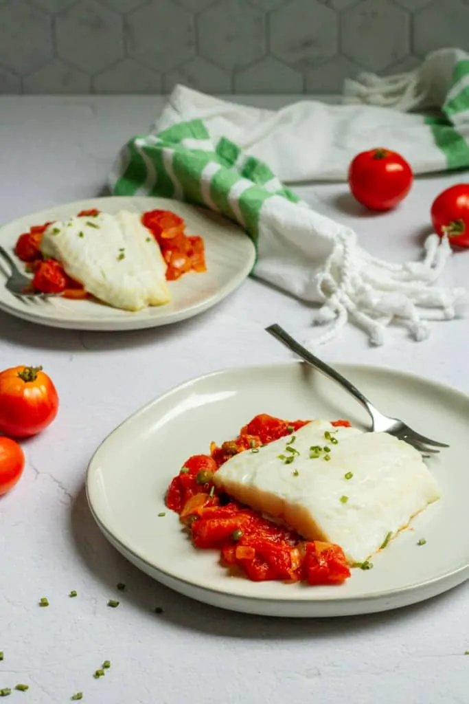 baked lingcod on plates with tomato sauce