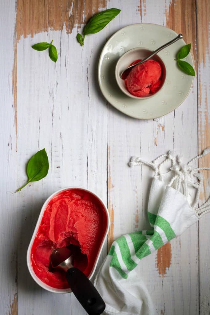 Strawberry basil sorbet in a container + bowl