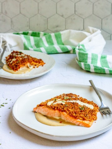 Baked mustard salmon on a plate with tahini dressing