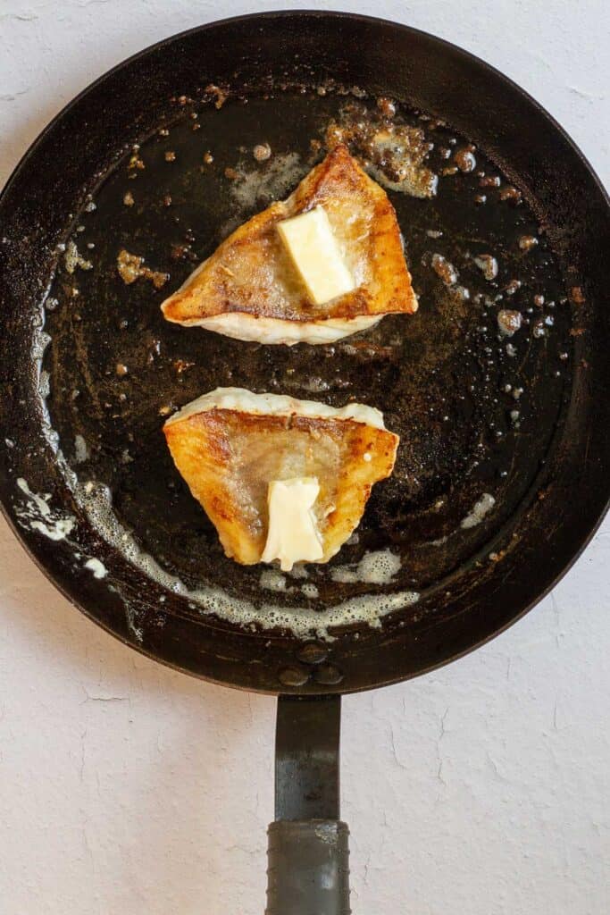 rockfish fillets in pan, flipped so golden side is up.