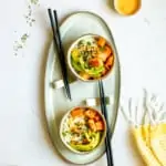 spicy salmon poke bowls on a serving tray with chopsticks