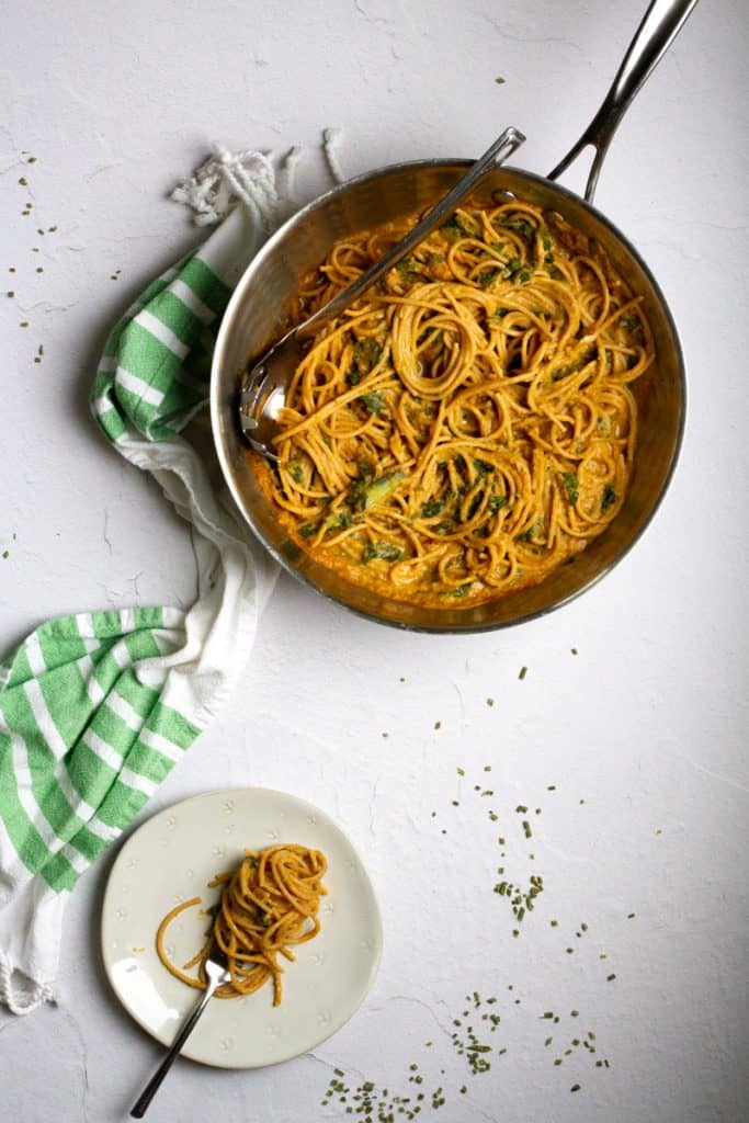 acorn squash pasta with kale in a pan and on a plate