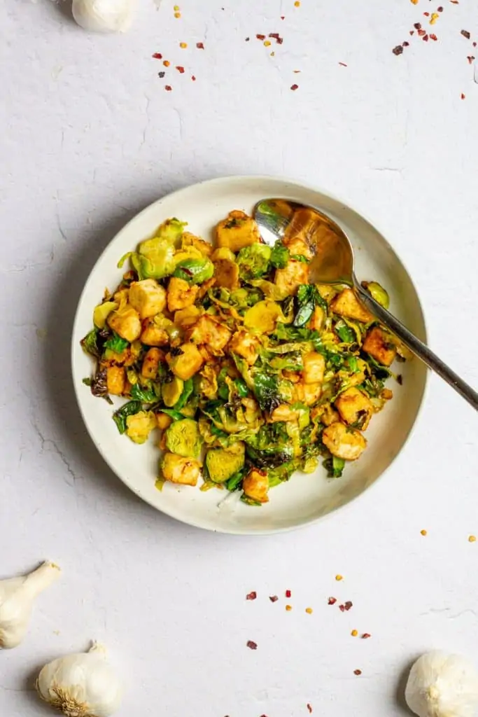chili garlic tofu with brussels sprouts in a bowl