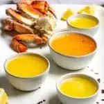 crab butter sauce on a platter with crab legs