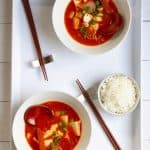 Vegan kimchi soup in bowls on a serving tray