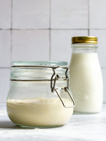 Milk Kefir Sourdough starter in a jar with milk kefir in the background