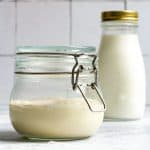 Milk Kefir Sourdough starter in a jar with milk kefir in the background