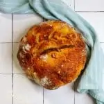 rosemary garlic sourdough bread on a tile countertop with a towel