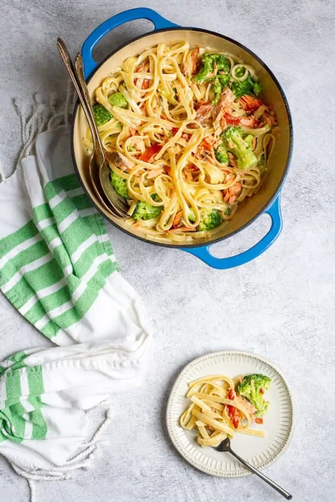 salmon broccoli pasta in a serving dish and on a plate.