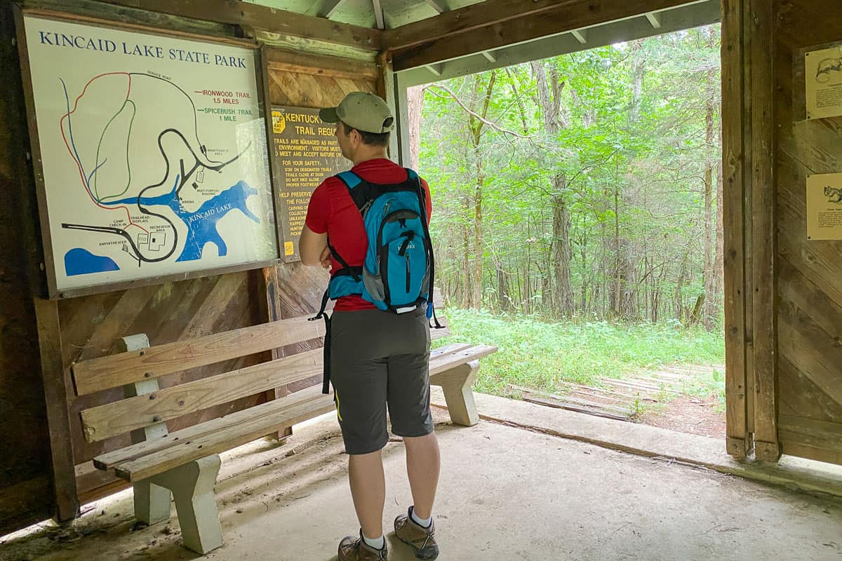 Man wearing hiking gear looking at trail map.