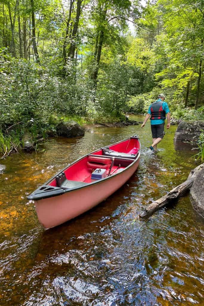 Pulling Canoe Through a Stream.